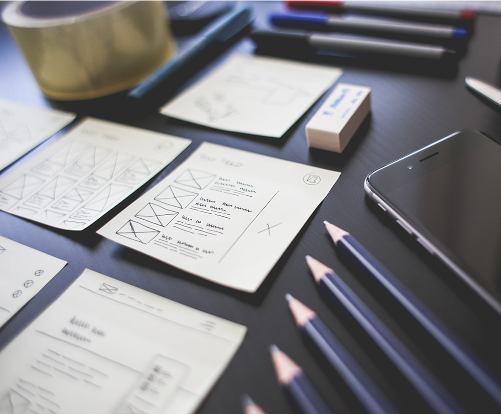 Mesa con papeles escritos, lapiceros, borrador y teléfono móvil