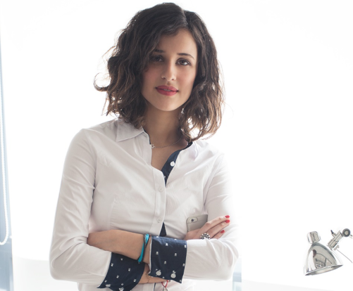 Mujer ejecutiva cruzada de brazos con blusa blanca y puños doblados en color azula marino